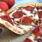 a slice of keto pizza lifted off the plate