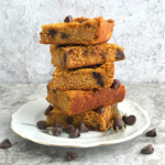 Keto pumpkin Chocolate chip blondies stacked in a plate with chocolate chips tossed around