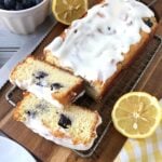 two slices cut off a lemon blueberry bread with sliced lemons at the sides.