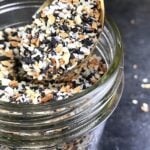 A spoon full of everything bagel seasoning from a jar