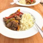 A white plate of cauliflower rice and mushroom stir fryt