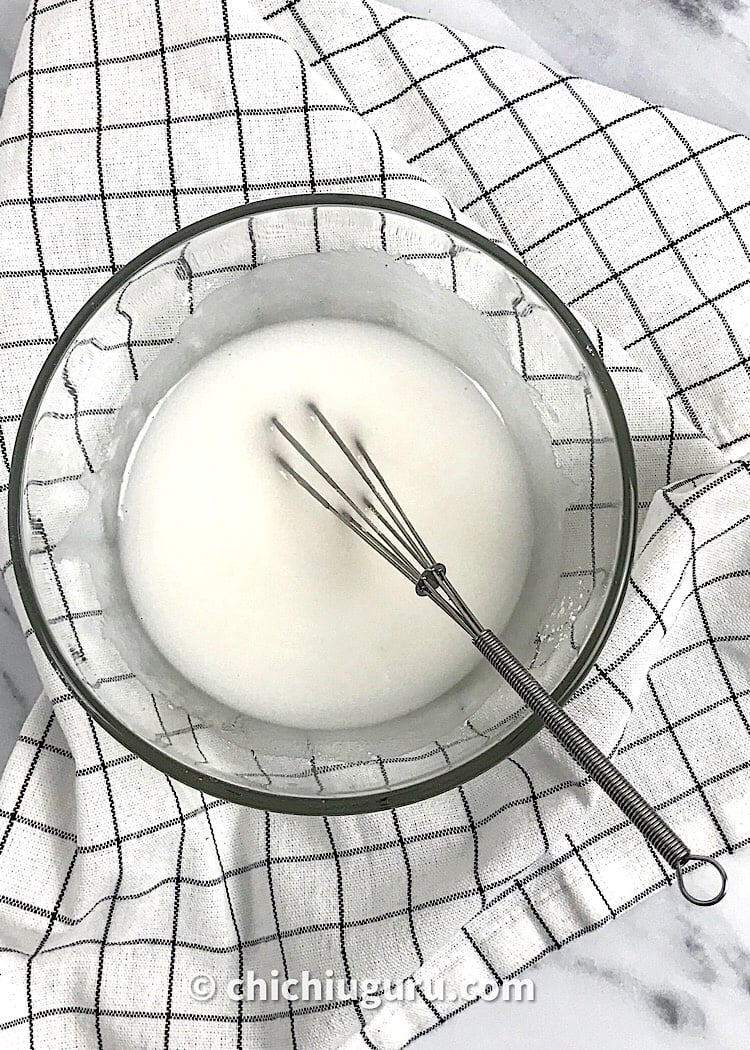 top view of keto glaze in a glass bowl with a mini whisk in it